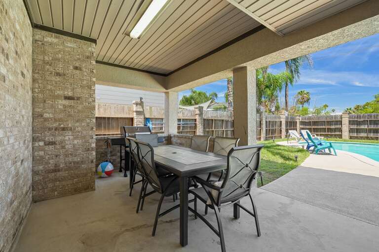 Outdoor dining space next to the private pool with propane grill