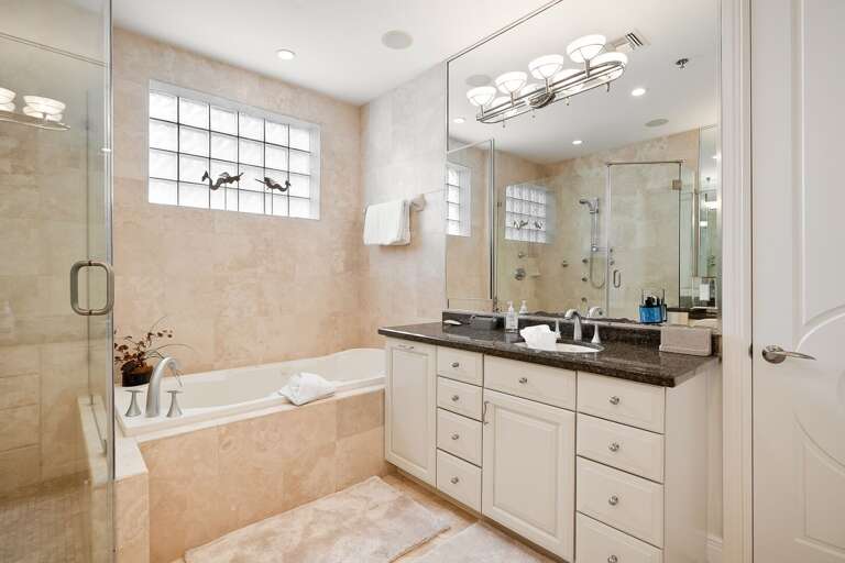 Bathroom in Master Bedroom B with tub, tiled walk-in shower, and double vanity sinks. Bathroom in Master Bedroom B with tub, tiled walk-in shower, and double vanity sinks.