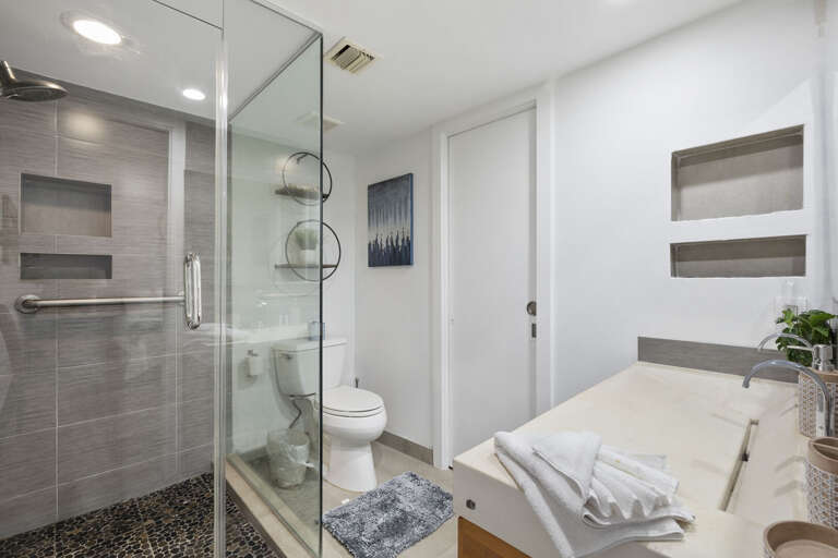 Master bathroom with tiled walk-in shower and double vanity sink.