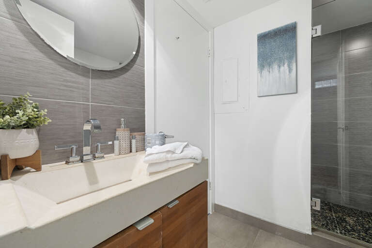 Shared bathroom with tiled walk-in shower. Accessible from bedroom 3 or the main hallway.