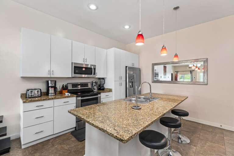 Stylish kitchen with stainless steel appliances and large center island/bar.