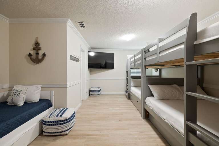 Guest bedroom on the ground floor features bunk beds with full beds and twin trundle beds.