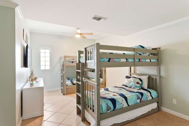 2nd guest bedroom (ground floor) features two sets of twin bunk beds, with two additional twin trundle beds (6 beds total) and a flat screen TV.