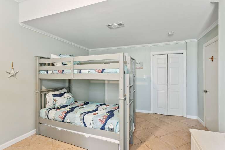 Guest bedroom features two sets of twin bunk beds, with two additional twin trundle beds (6 beds total) and a flat scree TV.  (Ground Floor).