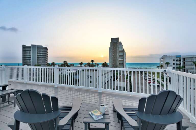 Balcony With Chairs Overlooking Sunset And Palm Trees