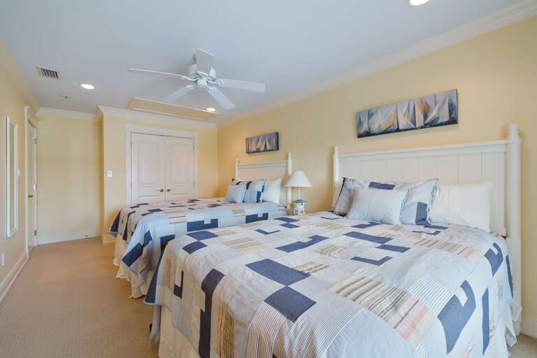 Twin Beds In Light-colored Room With Wall Art And Lamps
