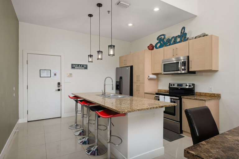 Residential Kitchen With Bar Stools And Stainless Steel Appliances