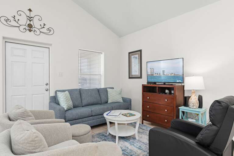 Ample seating around the flat screen TV in the living room.