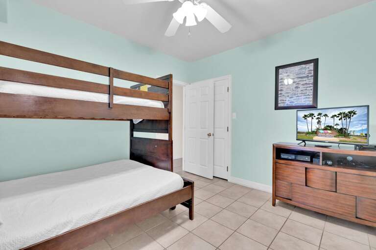 Third bedroom located on the ground level features twin over full bunk beds and flat screen TV.