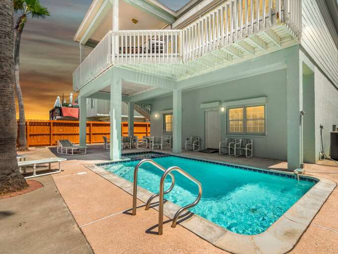 Backyard Swimming Pool With Stairs And Balcony At Dusk