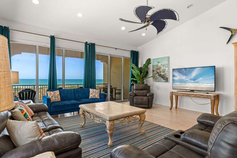 Living area surrounds a flat screen TV and direct balcony access
