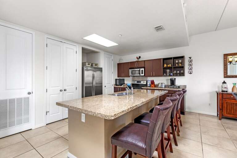 Kitchen Interior With Bar Stools And Stainless Steel Appliances