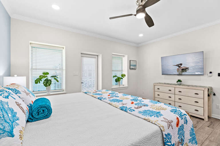 Master bedroom features a King bed, flat screen TV, a private bathroom & access to the front balcony.