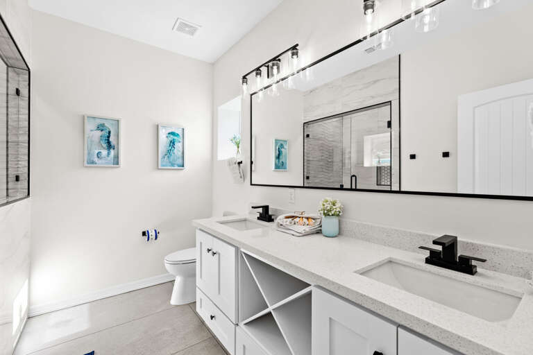 Private bathroom attached to the third bedroom entails double sinks, large vanity mirror & beautiful walk-in shower.