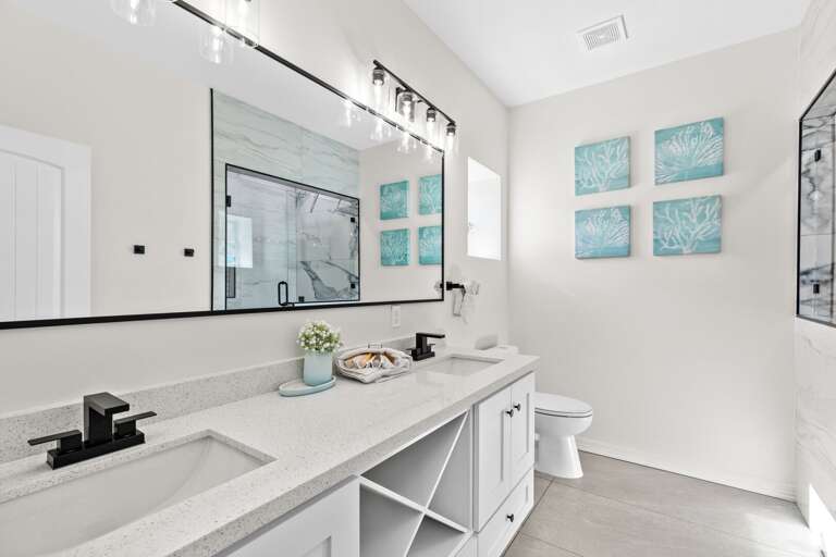 Private bathroom attached to second bedroom entails double sinks, large vanity mirror & beautiful walk-in shower.