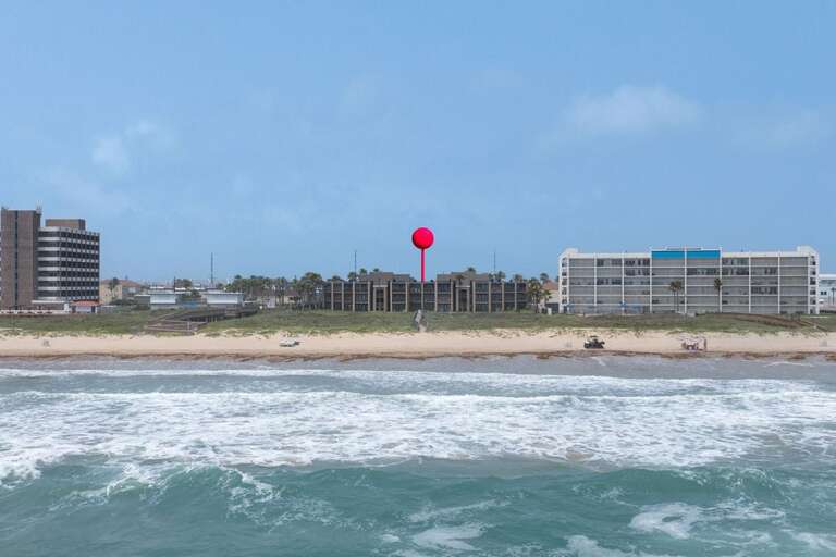 Blue Beach By Buildings Beneath A Bold Balloon