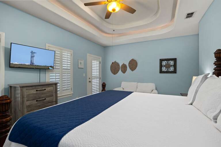 Ample natural light, cozy seating, and direct access to the ensuite bath.