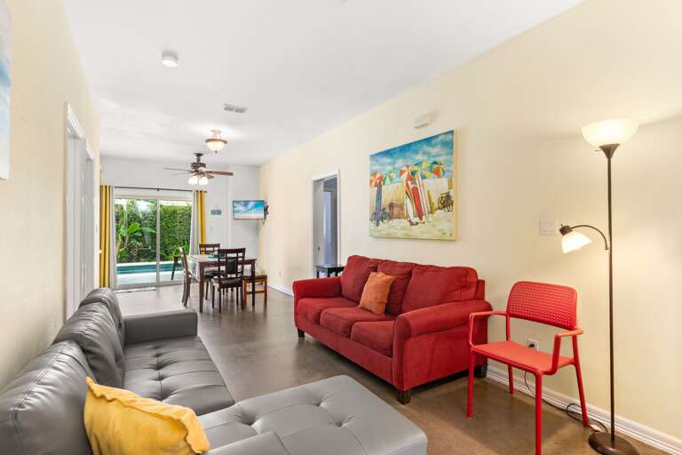 Brightly Lit Living Space With Plush Seating, Sleek Surfaces, And Vibrant Art In A Vacation Rental
