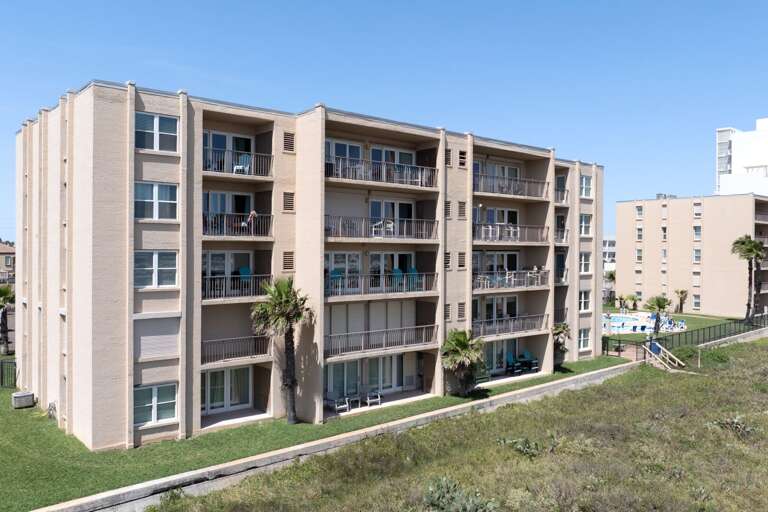 Beach House I Condominiums exterior—steps from the beach with easy access to both pools and parking.
