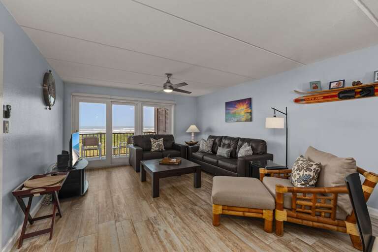 Bright oceanfront living room with floor-to-ceiling views of the Gulf. Wake up to gorgeous morning sunrises!