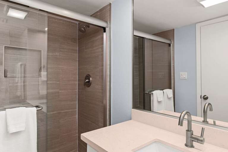 Guest Bathroom. Updated vanity area with contemporary finishes, large mirror, and ample lighting.
