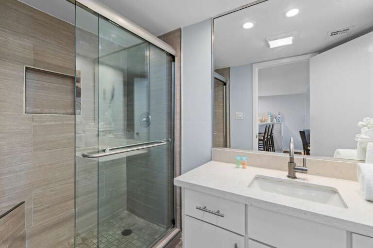 Guest Bathroom - Updated vanity area with contemporary finishes, large mirror, and ample lighting.