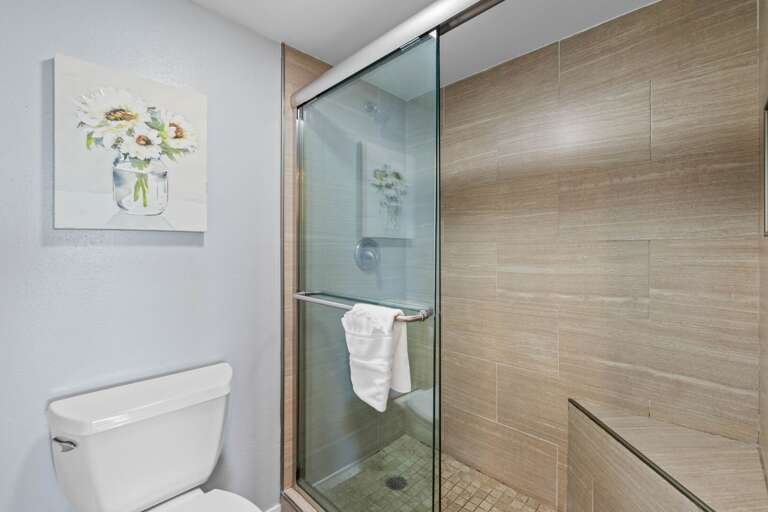 Master Bathroom - Bright and modern bathroom featuring a glass-enclosed shower, sleek tile design, and fresh towels.