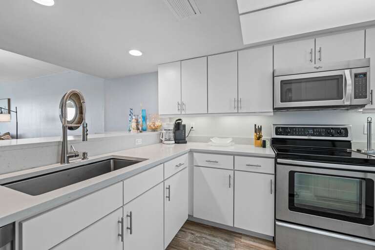 Sleek kitchen design with large sink, stylish backsplash, and bright natural lighting.