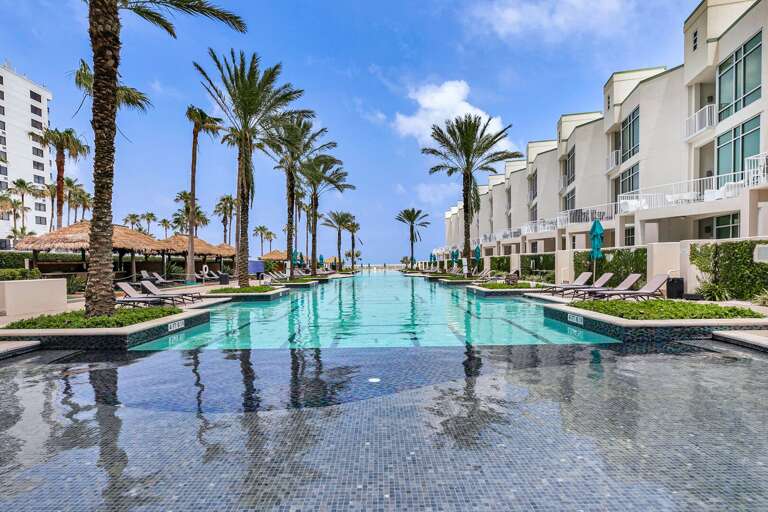 Relax in luxury at Sapphire's iconic resort-style pool surrounded by palm trees, cabanas, and endless sunshine.