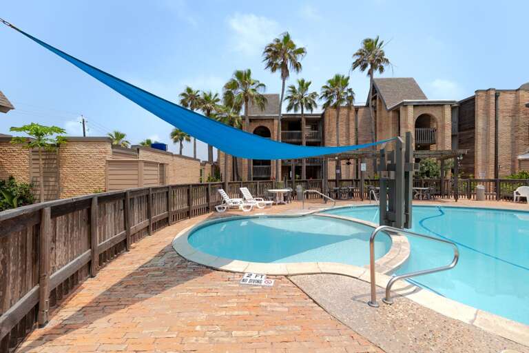 Enjoy Marisol's sparkling resort-style swimming pool, complete with a shaded canopy and comfortable seating perfect for cooling off after a beach day.