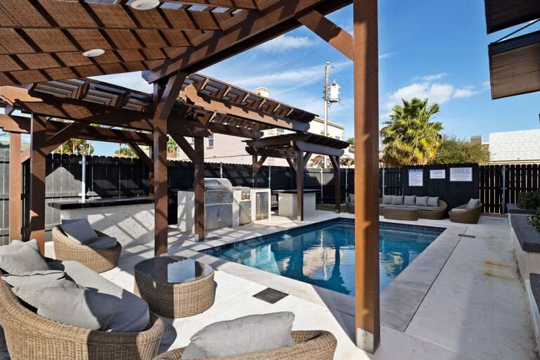 Poolside Pergola With Plush Seating And Barbecue