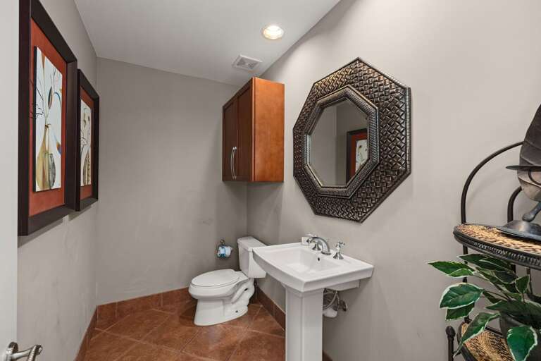 This convenient half bath offers a stylish vanity and is perfect for quick access from the living areas or guest bedrooms