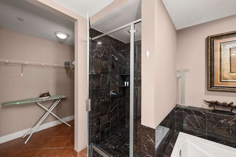 Luxuriate in the walk in shower with beautiful marble accents, creating a calming and spacious experience