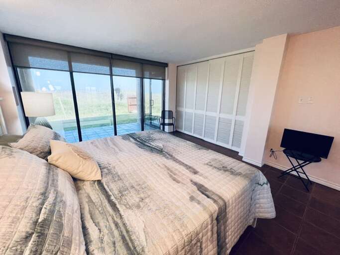 Large sliding glass doors in the primary bedroom provide views of the patio and natural light.