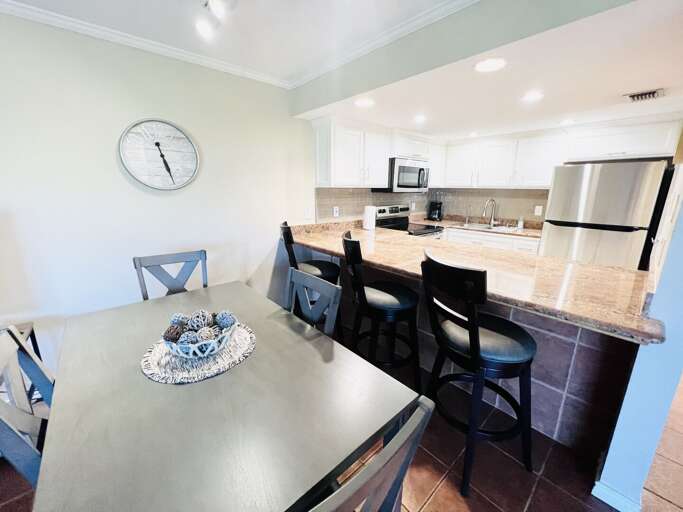 Open dining space with bar seating overlooking the kitchen, perfect for casual meals and entertaining.