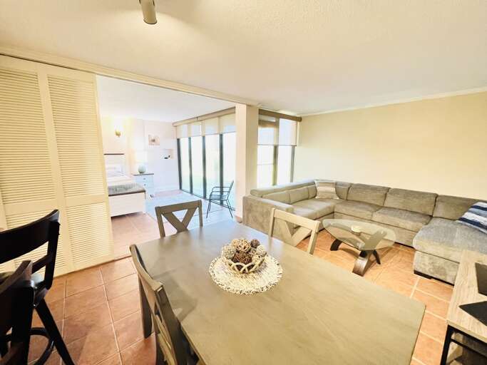 Primary bedroom opens to the living and dining areas, creating an open-concept feel. Sliding doors offer privacy when desired.