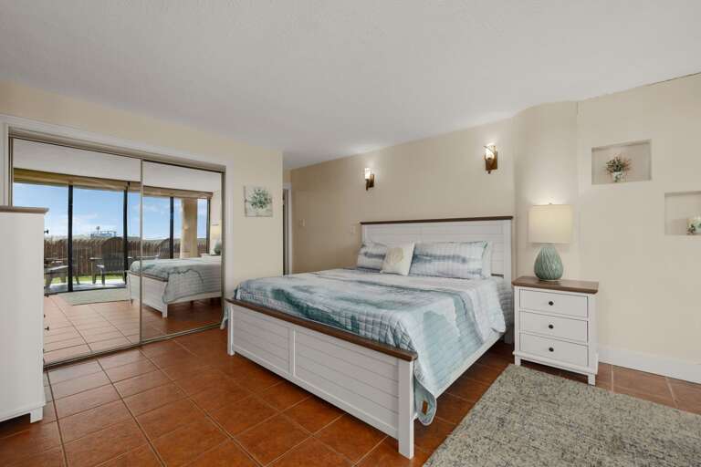 Bedroom With Bed, Mirrored Closet, And Balcony View