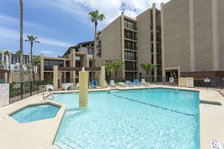 Spacious community pool with attached hot tub and sun deck, offering a relaxing retreat.