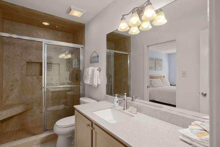 En suite bathroom with walk-in shower and bright vanity