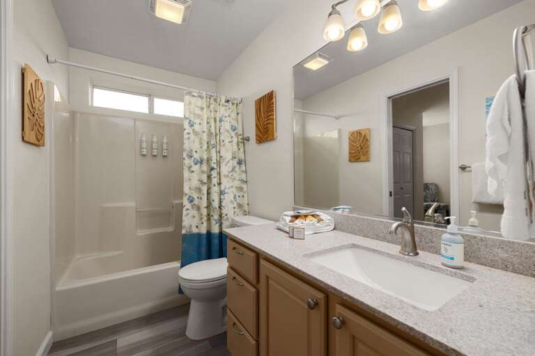The full bathroom has easy access from the downstairs living room and pool area