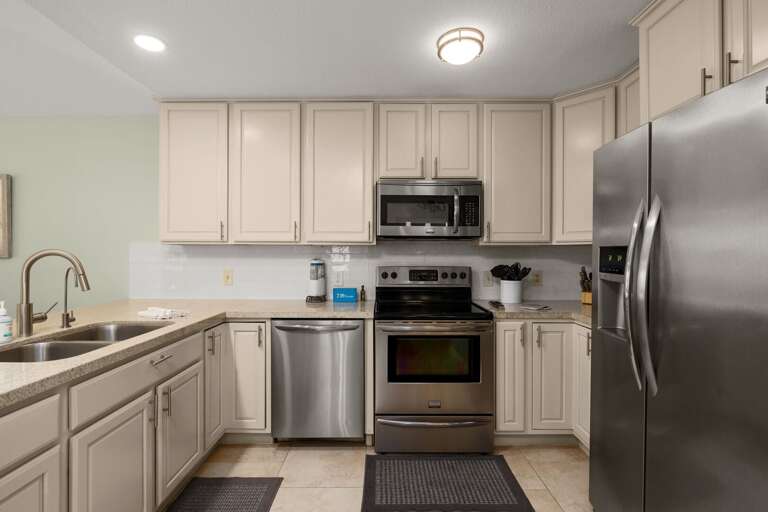 Fully stocked kitchen with stainless appliances and prep space