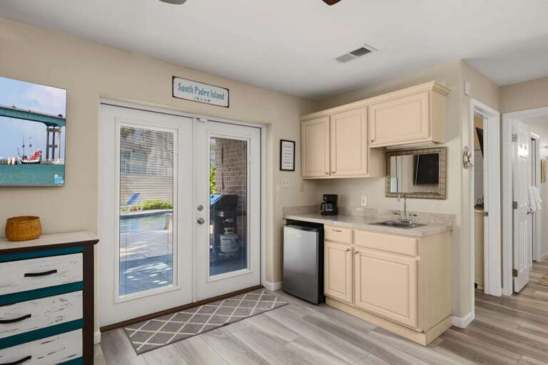 Kitchenette with sink and mini fridge, perfect for quick snacks and drinks just off the pool area