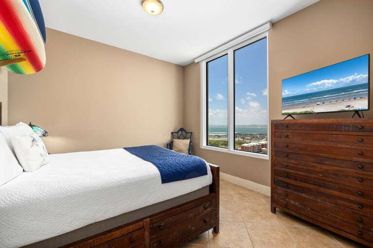 Guest bedroom with queen bed and TV