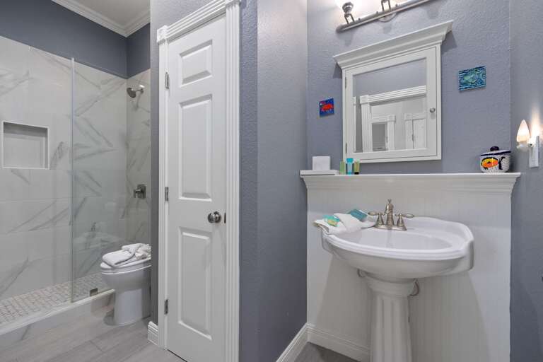 The shared bathroom features modern finishes and everything needed to get ready for another beach day.