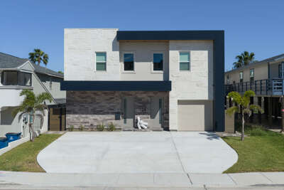 Welcome to La Casa de Los Suenos, your modern coastal getaway on South Padre Island! Your rental is on the left.