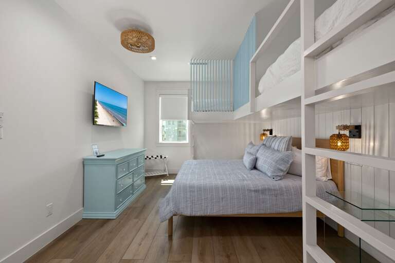 Enjoy flexible sleeping arrangements with a queen bed and twin bunk beds in this inviting guest bedroom.