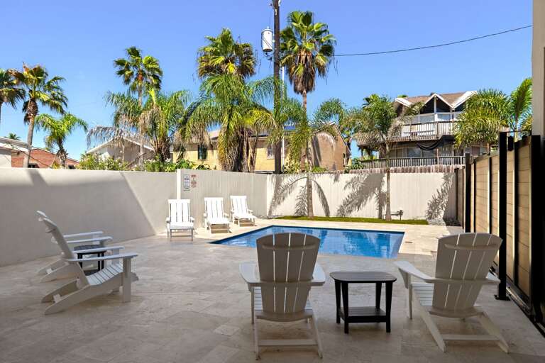 Spend sunny afternoons relaxing beside the private pool, surrounded by comfortable outdoor seating and palm trees.