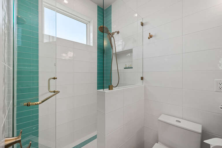 Enjoy the convenience of a beautifully updated guest bathroom with a glass shower enclosure and modern finishes.