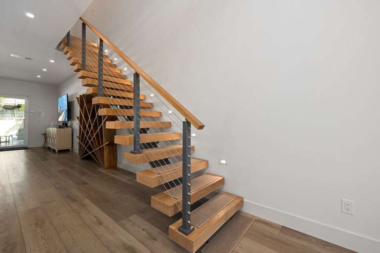 The beautiful floating staircase adds a modern architectural touch while connecting the home's living spaces.