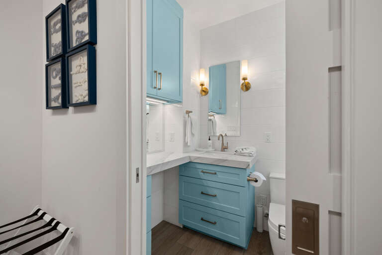 A convenient guest bathroom features a blue vanity, modern fixtures, and easy access from the bunk room.
